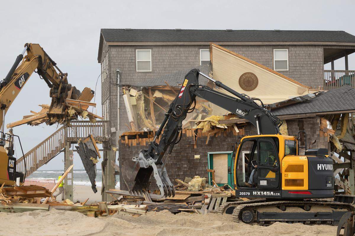 A demolition crew tears down a beach home Wednesday, Nov. 15, 2023 in Rodanthe. The National Park Service recently purchased two homes in Rodanthe as part of a pilot program to buy erosion-threatened properties and remove them before Mother Nature does.