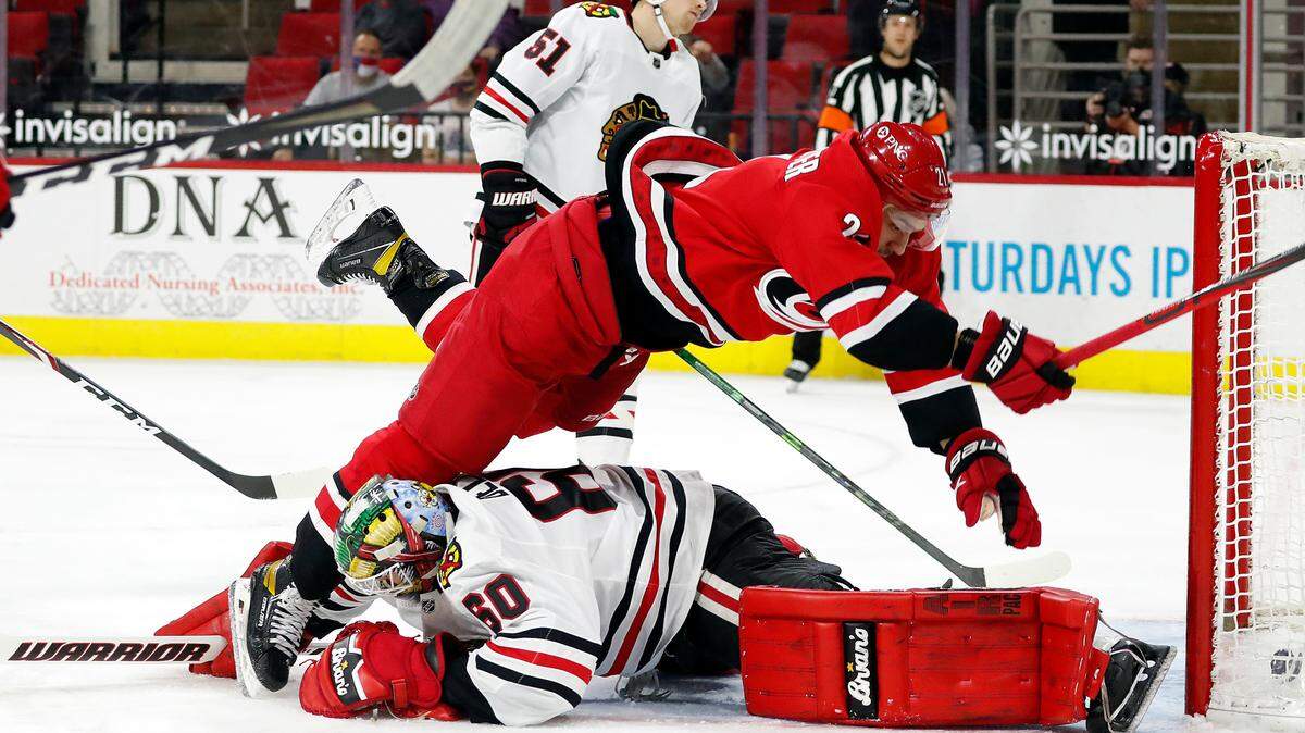 Carolina Hurricanes’ Nino Niederreiter (21) collides with Chicago Blackhawks goaltender Collin Delia (60) after scoring a goal during the second period of an NHL hockey game in Raleigh, N.C., Tuesday, May 4, 2021. (AP Photo/Karl B DeBlaker)
