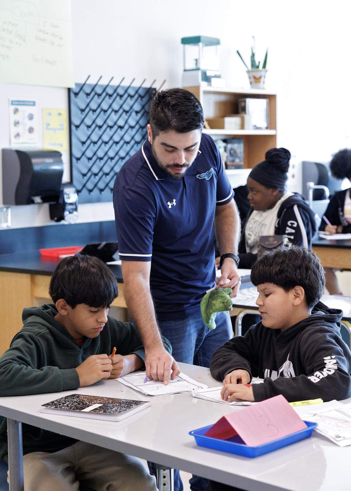 Science teacher Eduardo Estrada speaks with students during a class on Friday, Aug. 15, 2025, at Neuse River Middle School in Raleigh, N.C.
