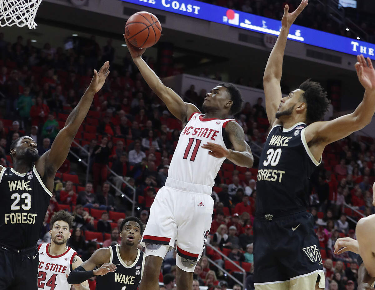 N.C. State’s Markell Johnson (11) drives past Wake Forest’s Olivier Sarr (30) during the first half of the N.C. State Wolfpack’s game against the Wake Forest Demon Deacons at PNC Arena in Raleigh, N.C., Friday, March 6, 2020.