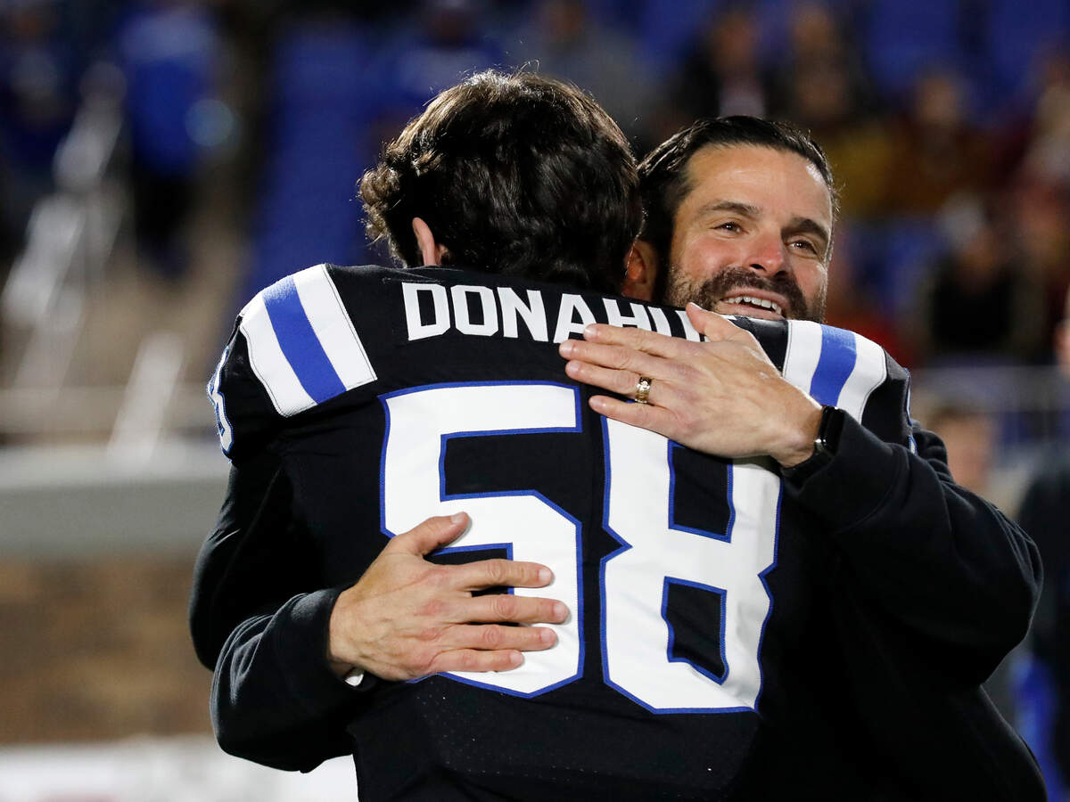 Duke head coach Manny Diaz hugs Casey Donahue during a recognition for seniors prior to the Blue Devils’ game against Virginia Tech on Saturday, Nov. 23, 2024, at Wallace Wade Stadium in Durham, N.C.