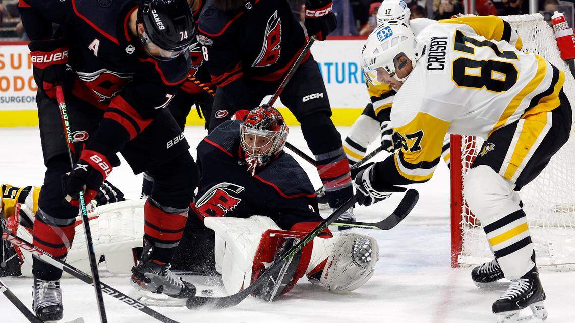 Pittsburgh Penguins forward Sidney Crosby (87) pokes at the puck in front of Carolina Hurricanes goaltender Frederik Andersen (31) with Jaccob Slavin (74) nearby during the third period of an NHL hockey game in Raleigh, N.C., Saturday, Jan. 14, 2023.