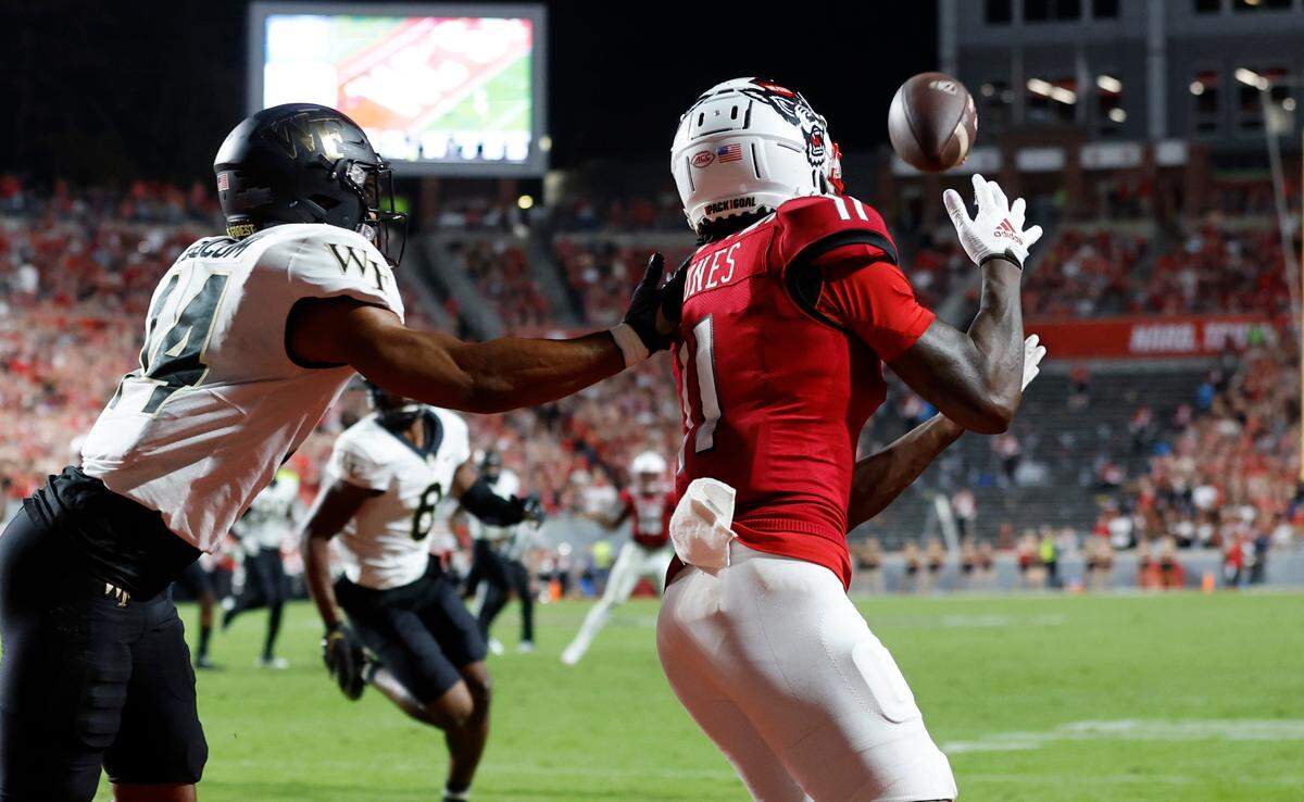 N.C. State wide receiver Darryl Jones (11) pulls in a 13-yard touchdown reception as Wake Forest defensive back Evan Slocum (14) defends during the first half of N.C. State’s game against Wake Forest at Carter-Finley Stadium in Raleigh, N.C., Saturday, Nov. 5, 2022.