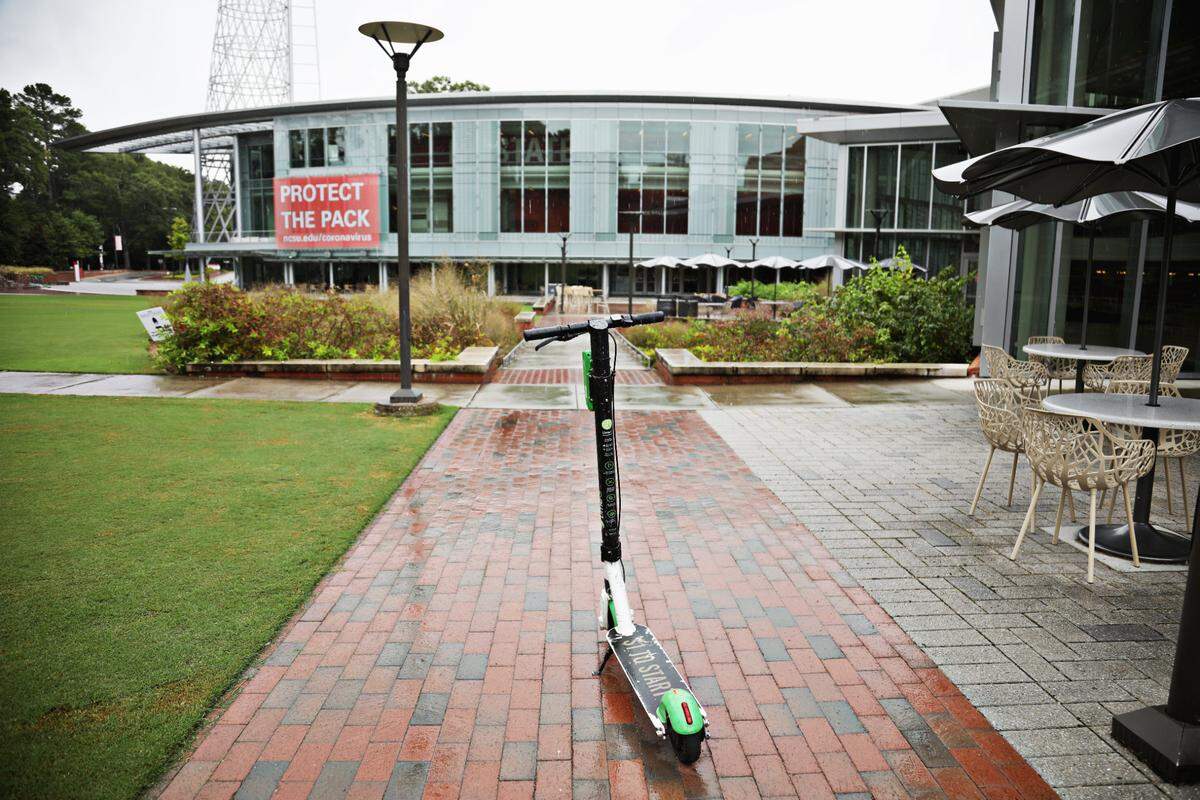 A lone electric scooter remains on a sidewalk outside Talley Student Union on the N.C. State University campus Wednesday, Sept. 9, 2020.