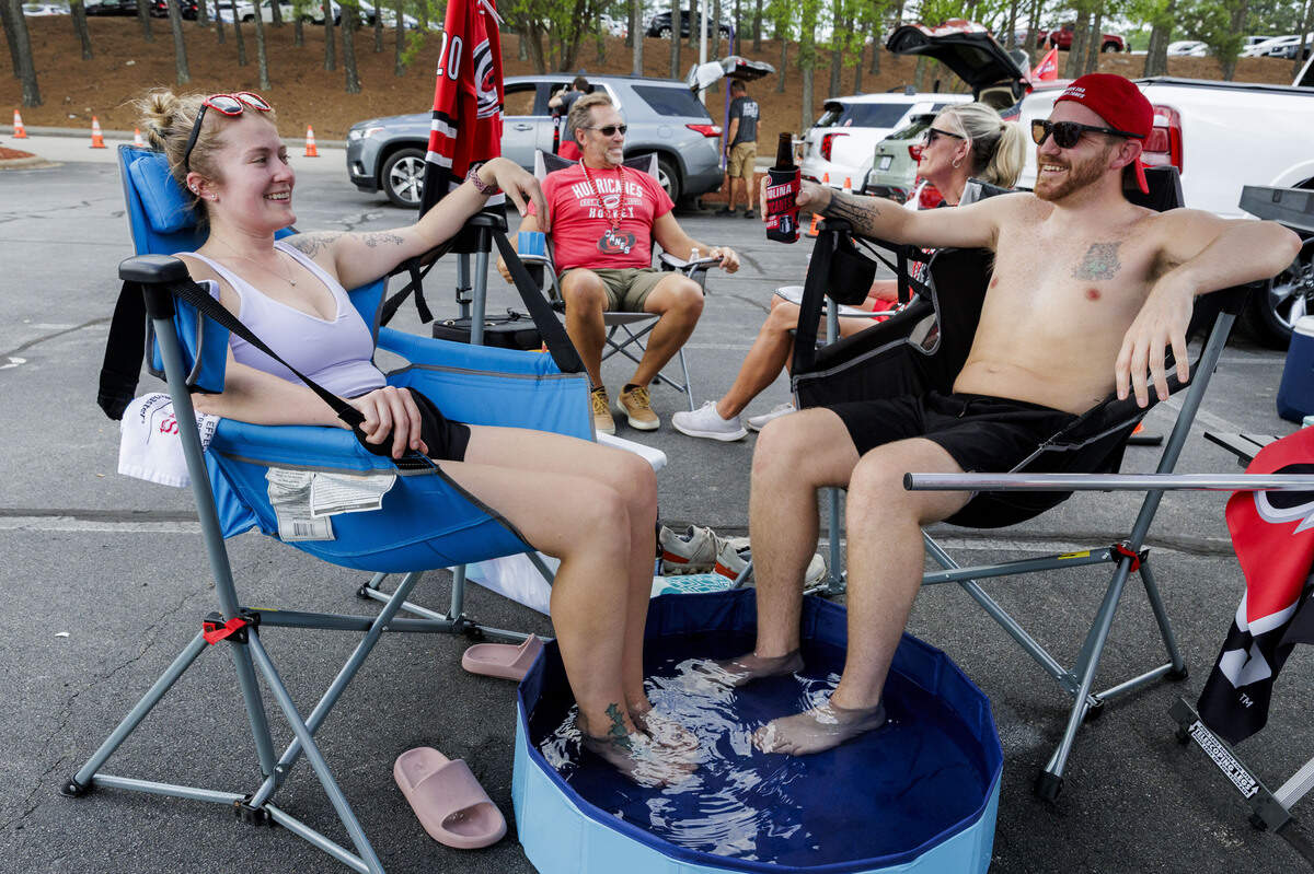Myranda Miller and Kaleb Snide (L-R) keep themselves cool with a miniature pool in the parking lot of the Lenovo Center on June 11, 2026, in Raleigh, North Carolina. The Carolina Hurricanes take on the Vegas Golden Knights for Game 5 of the Stanley Cup Final.