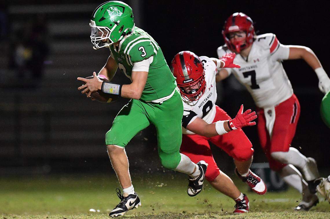 Cary quarterback Nick Grena (3) runs for the first down ahead of Middle Creek's Cullen Hunt (9) during the first half.  The Cary Imps and the Middle Creek Mustangs met in a conference football game in Cary, N.C. on October 24, 2025