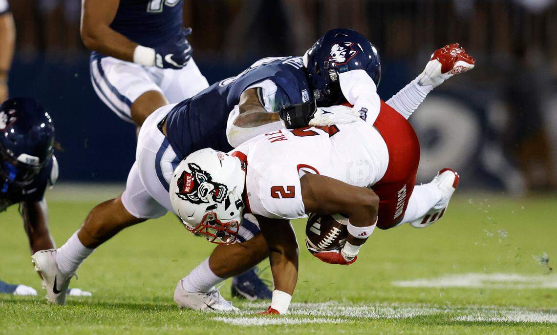 N.C. State running back Michael Allen (2) dives for extra yards as Connecticut linebacker Jackson Mitchell (8) tackles him during the first half of N.C. State’s game against UConn at Rentschler Field in East Hartford, Conn. Thursday, August 31, 2023.
