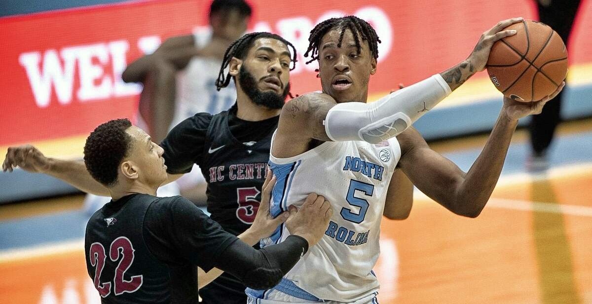 N.C. Central’s Deven Palmer (5) and C.J. Keyser (22) defend North Carolina’s Armando Bacot (5) during the second half on Saturday, December 12, 2020 at the Smith Center in Chapel Hill, N.C.