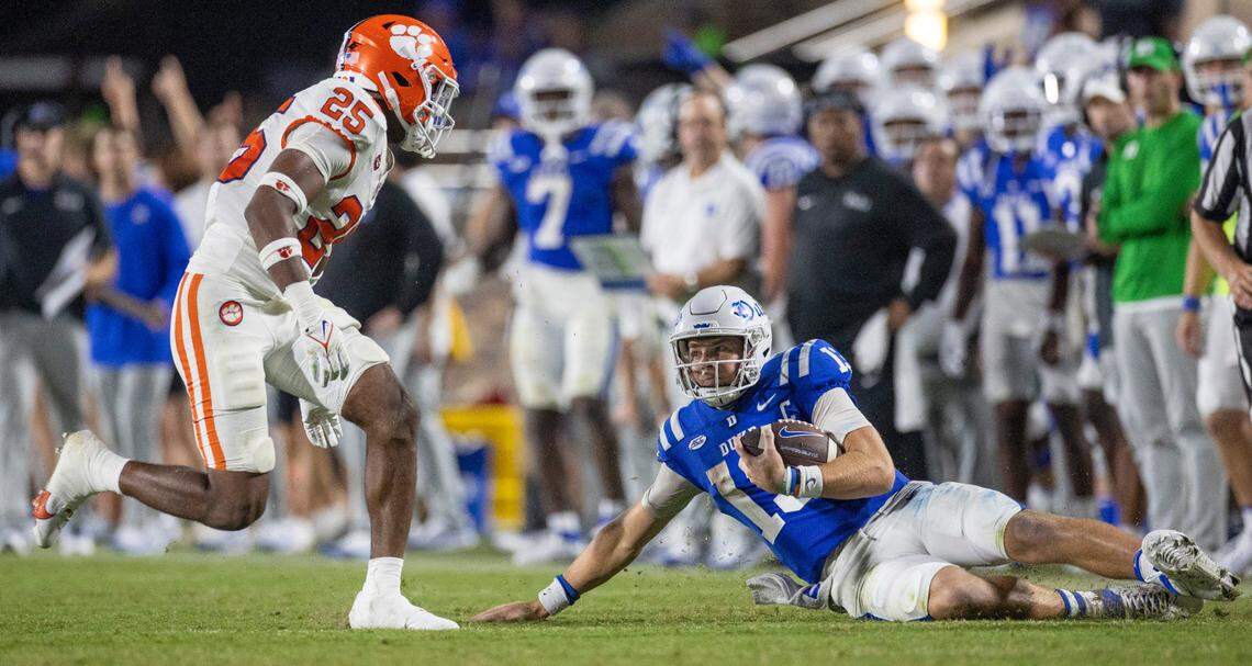 Duke quarterback Riley Leonard (13) slides under Clemson’s Jalyn Phillips (25) after an 11-yard gain in the closing minutes of play on Monday, September 4, 2023 at Wallace Wade Stadium Stadium in Durham, N.C.