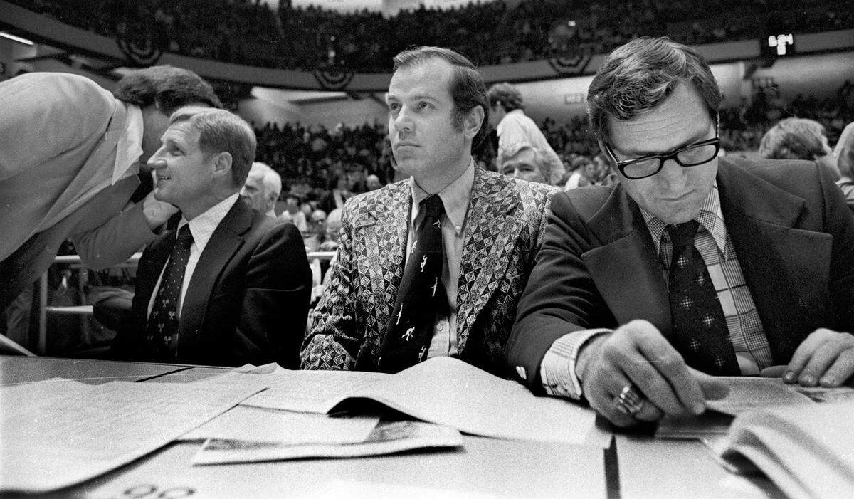 UNC coach Dean Smith (right) reviews stats as he sits with assistant coach Bill Guthridge (middle) and NC State head coach Norm Sloan (left) at the 1974 ACC Tournament in Greensboro, NC.