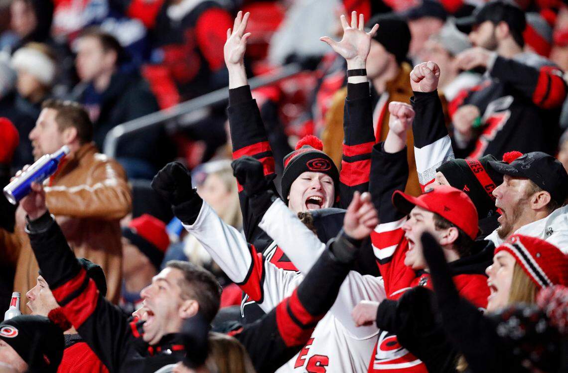 Fans celebrate a goal by the Canes during the second period of the NHL Stadium Series game between the Carolina Hurricanes and the Washington Capitals at Carter-Finley Stadium in Raleigh, N.C., Saturday, Feb. 18, 2023.