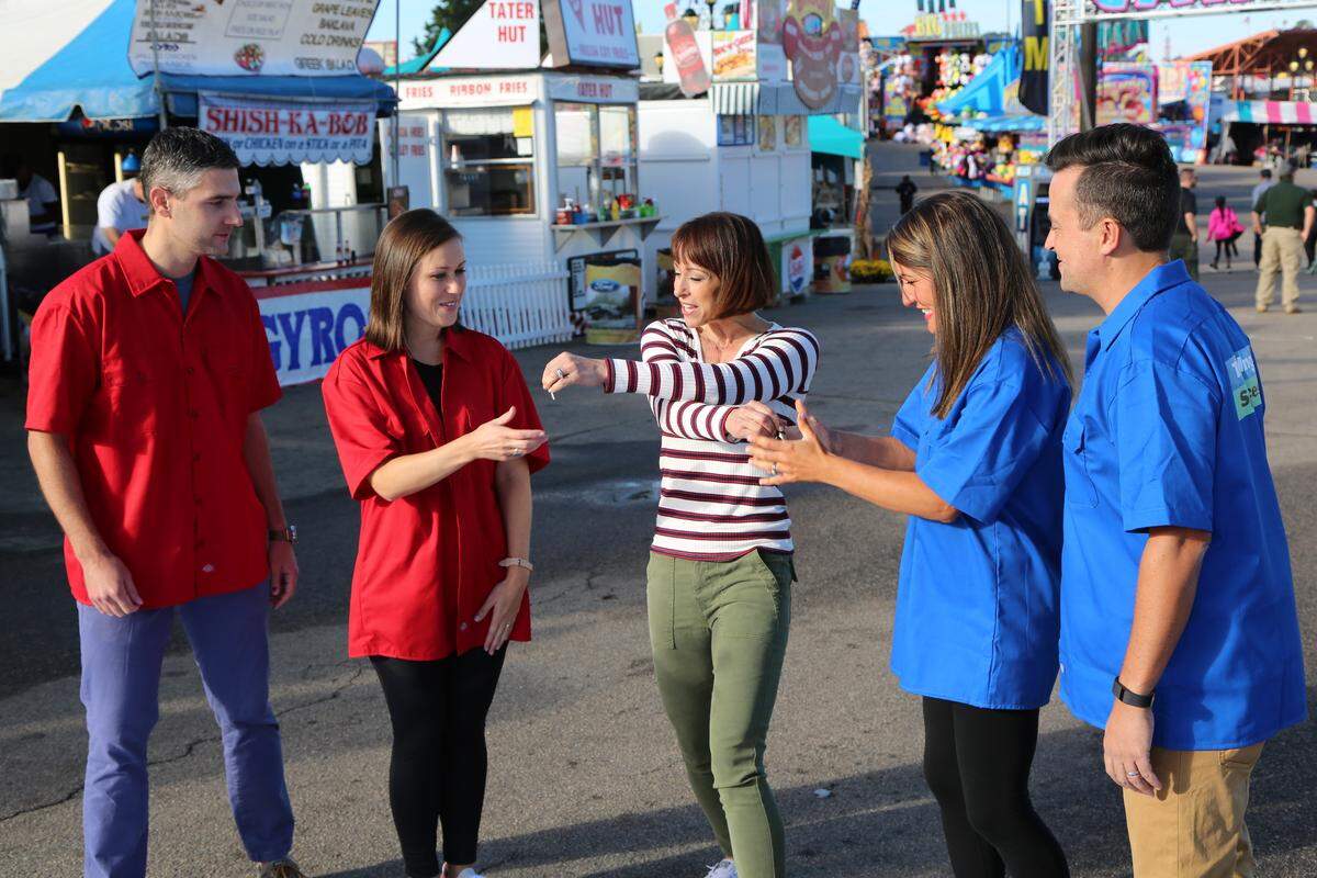 Ashley and David Brown (in red) and Angie and Ryan Tucker (in blue) grab each others keys from “Trading Spaces” host Paige Davis during the key swap at the N.C. State Fair in Raleigh.