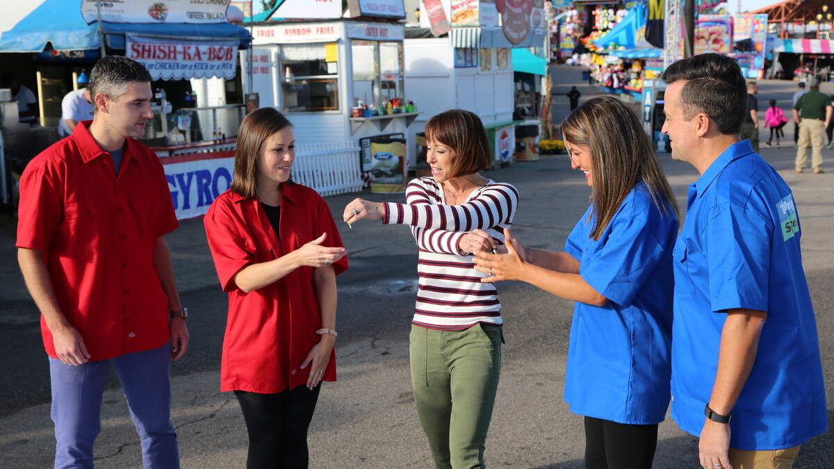 Ashley and David Brown (in red) and Angie and Ryan Tucker (in blue) grab each others keys from “Trading Spaces” host Paige Davis during the key swap at the N.C. State Fair in Raleigh.