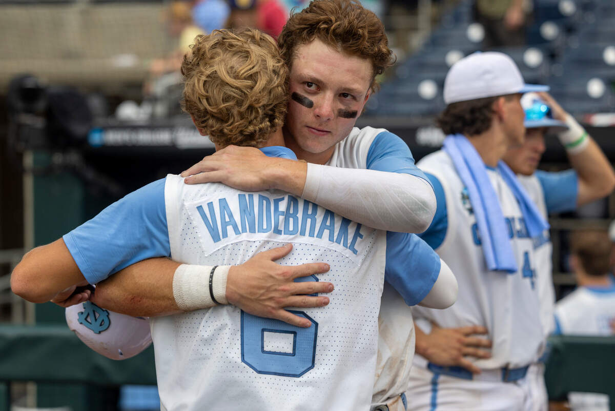North Carolina outfielder Vance Honeycutt (7) embraces designated hitter Jackson Van De Brake (6) following the Tar Heels’ season ending 9-5 loss to Florida State in game nine of the College World Series on Tuesday, June 18, 2024 at Charles Schwab Field in Omaha, Nebraska.