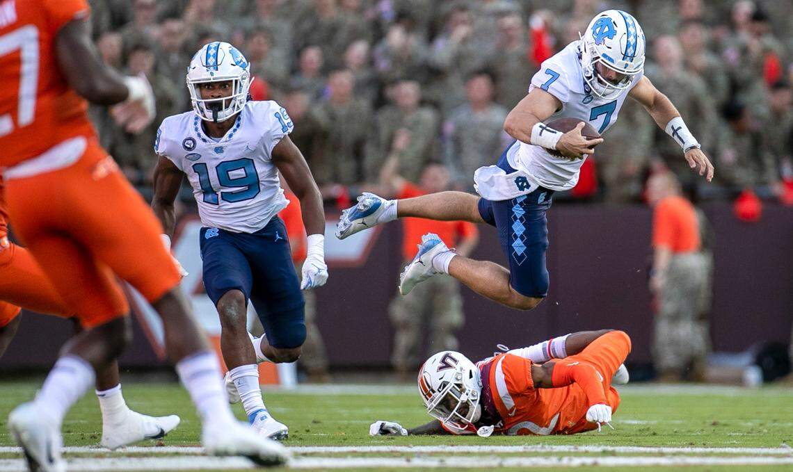 North Carolina quarterback Sam Howell (7) hurdles over Virginia Tech’s Jermaine Waller (2) for a first down in the second quarter on Friday, September 3, 2021 at Lane Stadium in Blacksburg, Va.