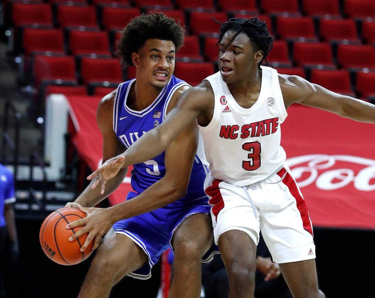 N.C. State’s Cam Hayes (3) tries to steal the ball from Duke’s Jaemyn Brakefield (5) during the second half of Duke’s 69-53 victory over N.C. State at PNC Arena in Raleigh, N.C., Saturday, February 13, 2021.
