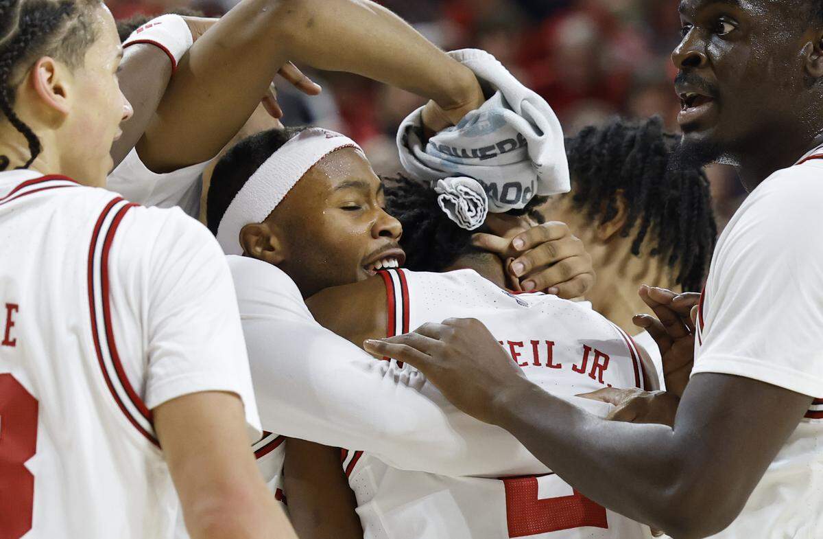 N.C. State's Tre Holloman and the team celebrate with Paul McNeil Jr. after McNeil broke the three-point record in the second half of N.C. State’s 108-72 victory over Texas Southern at Reynolds Coliseum in Raleigh, N.C., Wednesday, Dec. 17, 2025.