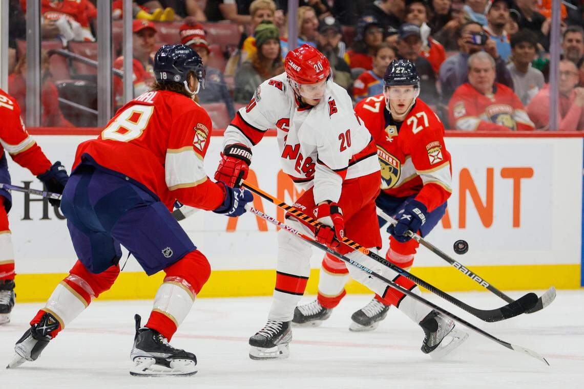 Apr 13, 2023; Sunrise, Florida, USA; Carolina Hurricanes center Sebastian Aho (20) controls the puck against Florida Panthers defenseman Marc Staal (18) and center Eetu Luostarinen (27) during the first period at FLA Live Arena. Mandatory Credit: Sam Navarro-USA TODAY Sports