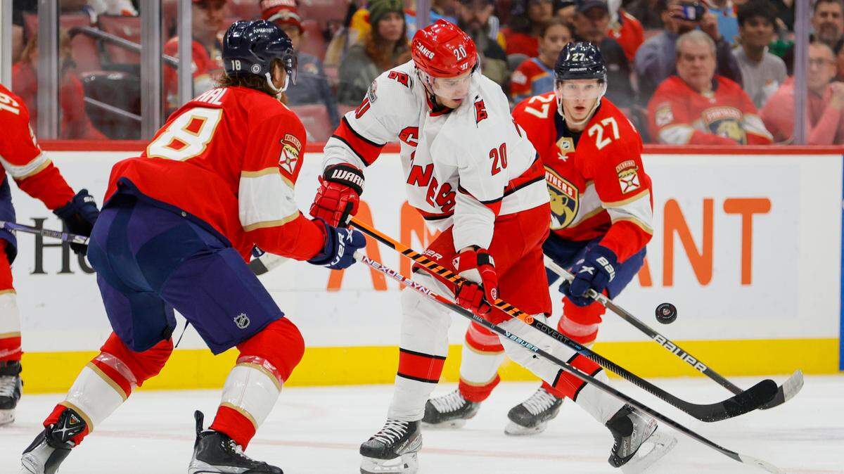 Apr 13, 2023; Sunrise, Florida, USA; Carolina Hurricanes center Sebastian Aho (20) controls the puck against Florida Panthers defenseman Marc Staal (18) and center Eetu Luostarinen (27) during the first period at FLA Live Arena. Mandatory Credit: Sam Navarro-USA TODAY Sports