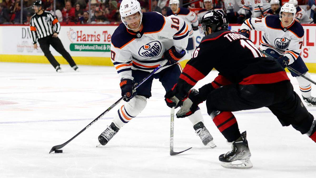 Edmonton Oilers’ Derek Ryan (10) shoots the puck past Carolina Hurricanes’ Vincent Trocheck (16) during the third period of an NHL hockey game in Raleigh, N.C., Sunday, Feb. 27, 2022. (AP Photo/Karl B DeBlaker)