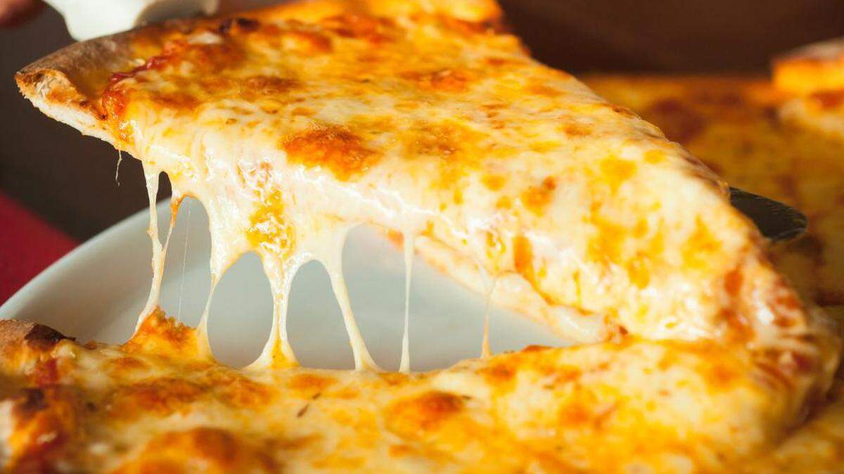 A slice of cheese pizza being picked up.