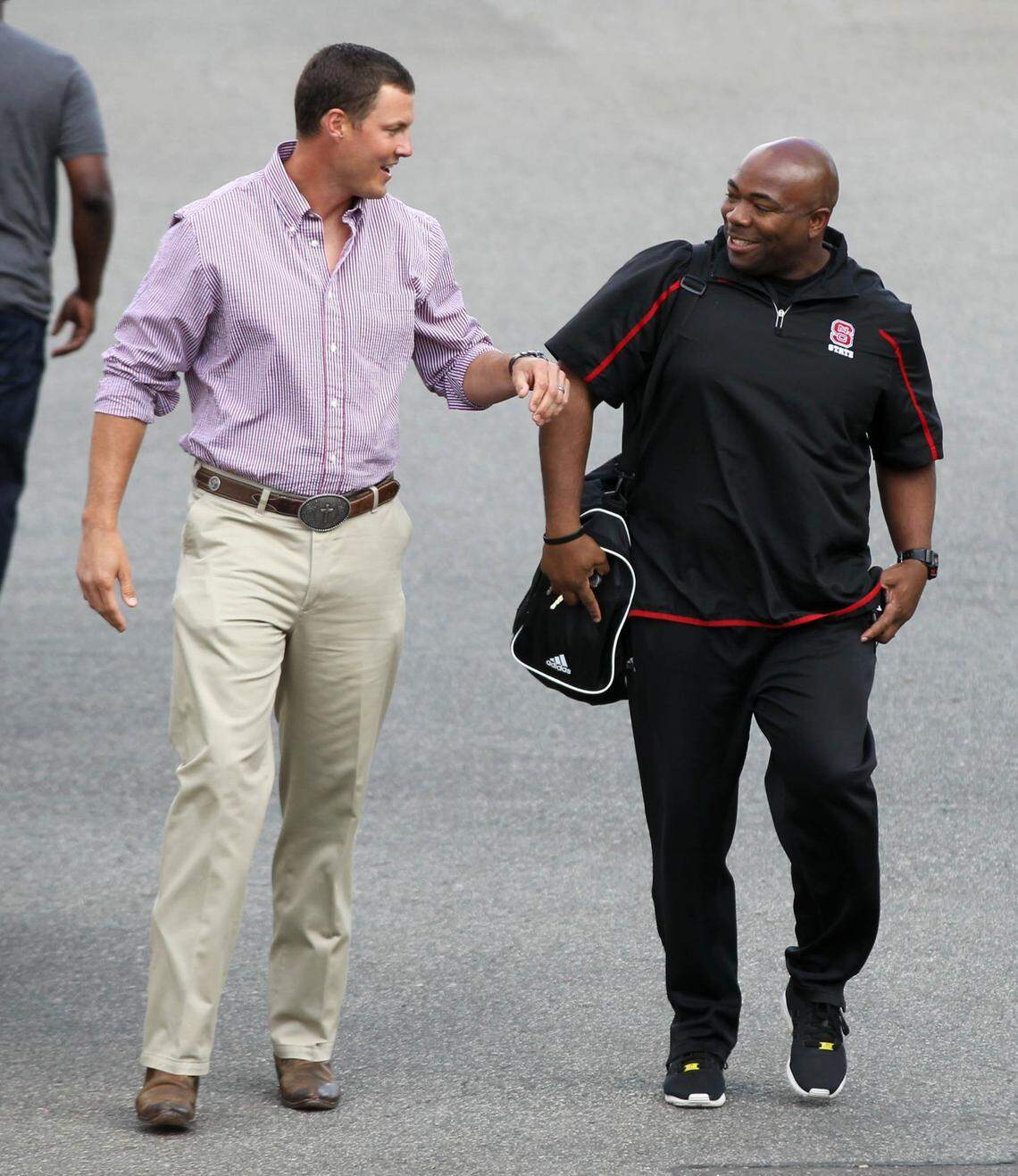 Former N.C. State star and current San Diego Chargers quarterback Philip Rivers talks with former teammate Dantonio Burnette, now N.C. State football’s Director of Strength & Conditioning, before entering the Murphy Center Friday, April 8, 2016.