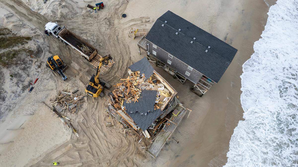 A demolition crew tears down a beach home Wednesday, Nov. 15, 2023 in Rodanthe. The National Park Service recently purchased two homes in Rodanthe as part of a pilot program to buy erosion-threatened properties and remove them before Mother Nature does.