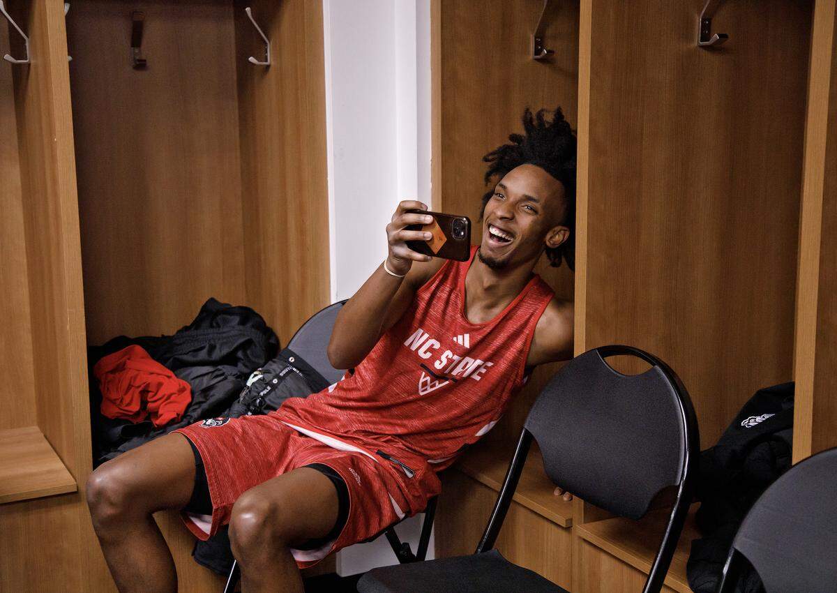 N.C. State’s Paul McNeil Jr. laughs as he records teammate Zymicah Wilkins’ interview with reporters in the locker room at University of Dayton Arena in Dayton, Ohio on Monday, March 16, 2026. The Wolfpack will face Texas in the First Four on Tuesday.