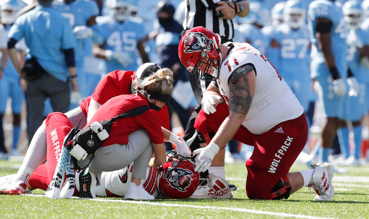 N.C. State guard Joe Sculthorpe (71) checks on Dylan Autenrieth (42) after Autenrieth was injured  during the first half of N.C. State’s game against UNC at Kenan Stadium in Chapel Hill, N.C., Saturday, Oct. 24, 2020.