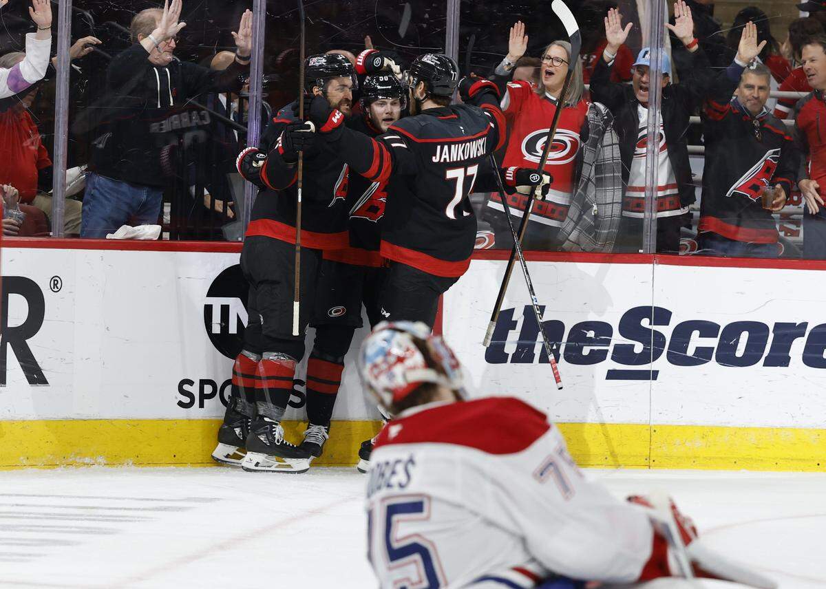 Carolina's William Carrier (28), Eric Robinson (50) and Mark Jankowski (77) celebrate after Robinson scored in the first period of the Hurricanes’ game against the Canadiens in game two of the Eastern Conference Finals at the Lenovo Center in Raleigh, N.C., Saturday, May 23, 2026.