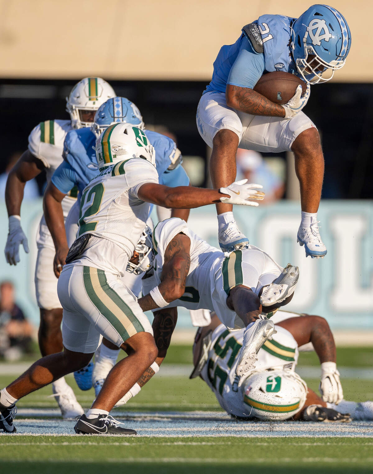 North Carolina running back Davion Gause (21) hurdles over Charlotte defensive back Al-Ma’hi Ali (0) for a 16-yard gain in the fourth quarter on Saturday, September 7, 2024 at Kenan Stadium in Chapel Hill, N.C.