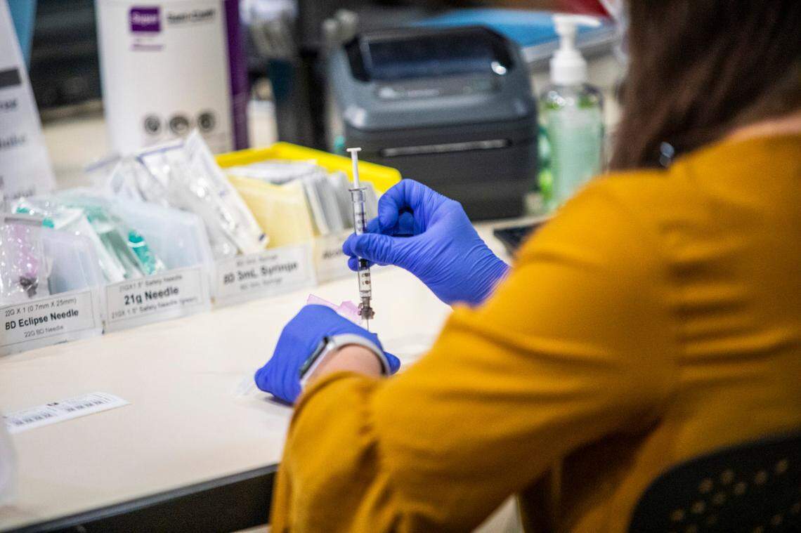 A healthcare worker prepares a Pfizer vaccine dose at a large-scale vaccination site at UNC’s Friday Center in Chapel Hill Tuesday, Jan. 19 2021. UNC Hospitals hope to administer 2500 first covid-19 vaccine doses at the Friday Center by the end of this week.