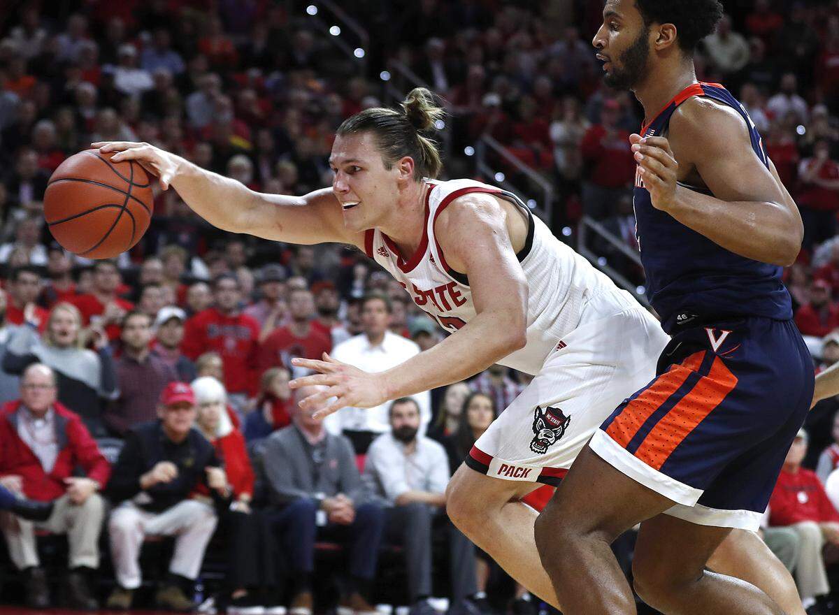 N.C. State’s Wyatt Walker (33) saves the ball from going out of bounds as Virginia’s Braxton Key (2) watches during the second half of Virginia’s 66-65 overtime victory over N.C. State at PNC Arena in Raleigh, N.C., Tuesday, January 29, 2019.