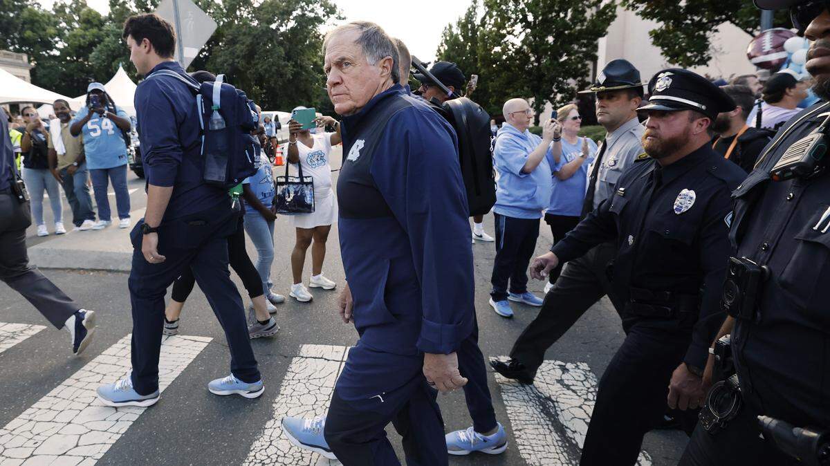 North Carolina head coach Bill Belichick cross South Road as he and the team head towards Kenan Stadium during the Old Well Walk before UNC’s game against TCU in Chapel Hill, N.C., Monday, Sept. 1, 2025.