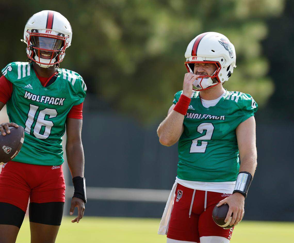 N.C. State quarterback CJ Bailey (16) laughs with quarterback Grayson McCall (2) during the Wolfpack’s first practice in Raleigh, N.C., Wednesday, July 31, 2024.
