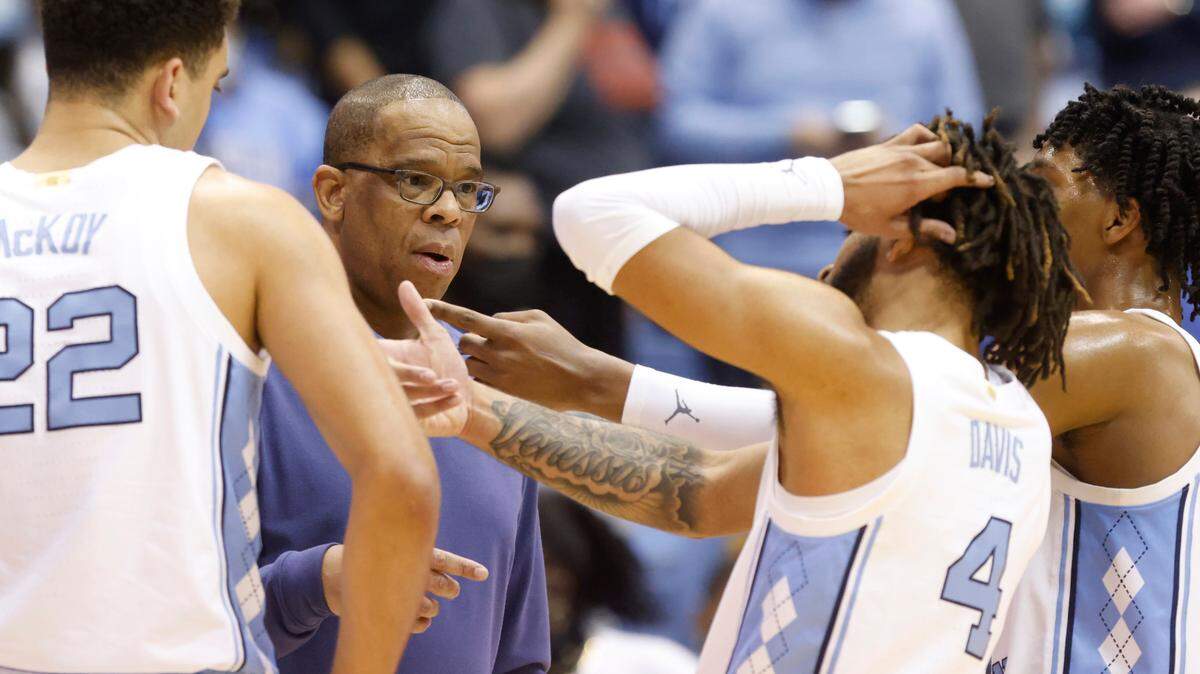 North Carolina head coach Hubert Davis talks with Justin McKoy (22), RJ Davis (4) and Caleb Love (2) during a timeout in the second half of UNC’s 78-68 victory over Virginia Tech at the Smith Center in Chapel Hill, N.C., Monday, Jan. 24, 2022.