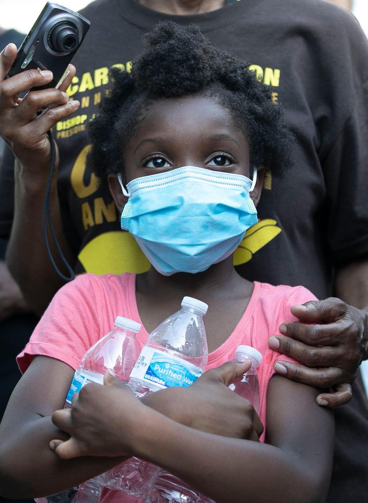 Eight-year-old Juliana Jacobs listens to speakers during a rally on the State Capital grounds following a Community of Faith Prayer Walk from Memorial Auditorium to the Capital on Saturday, June 6, 2020 in Raleigh, N.C.