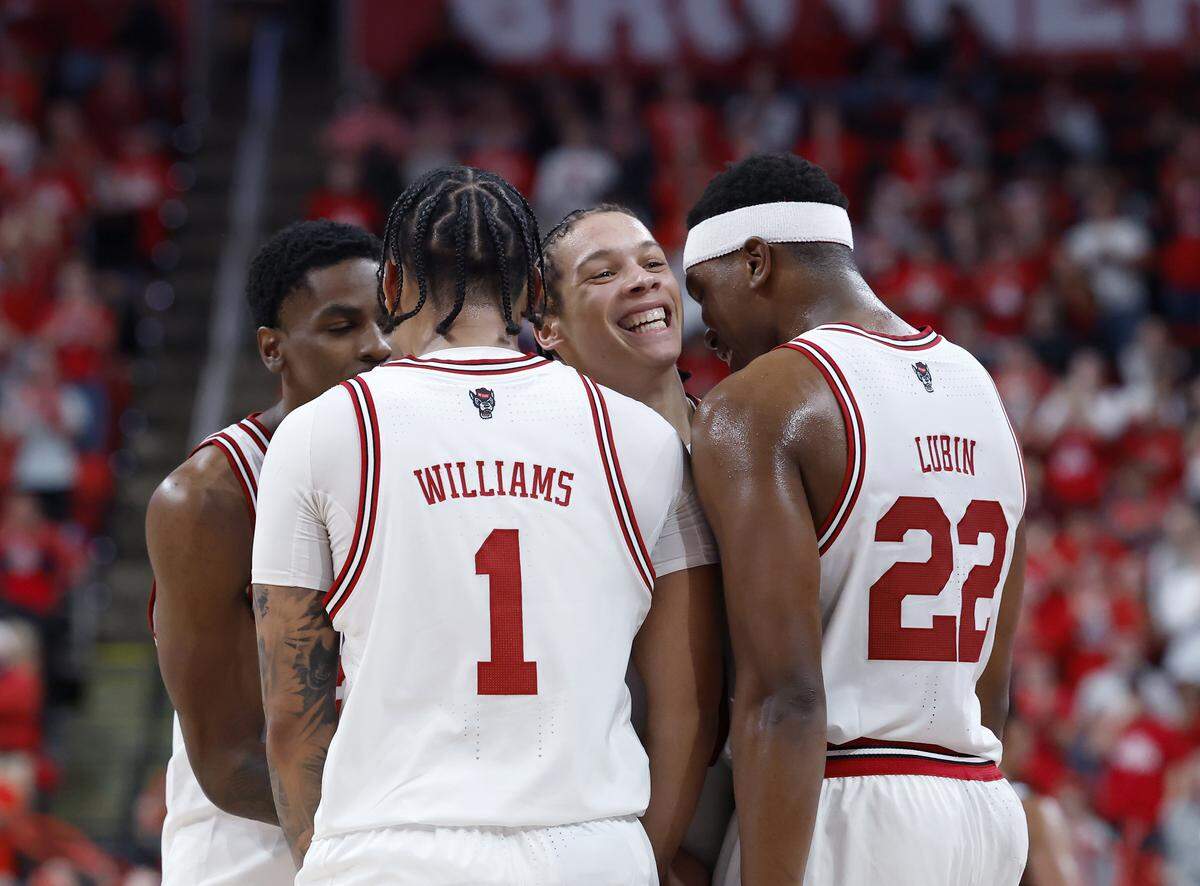 N.C. State’s Matt Able smiles as he is surrounded by teammates following a dunk during the second half of the Wolfpack’s 114-66 win over North Carolina Central on Monday, Nov. 3, 2025, at Lenovo Center in Raleigh, N.C.