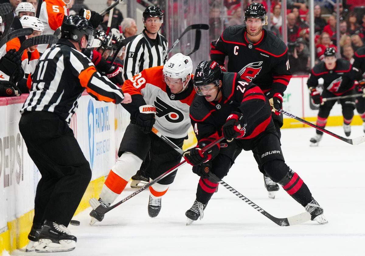 Carolina Hurricanes center Seth Jarvis (24) and Philadelphia Flyers right wing Matvei Michkov (39) battle over the puck during the second period at Lenovo Center.
