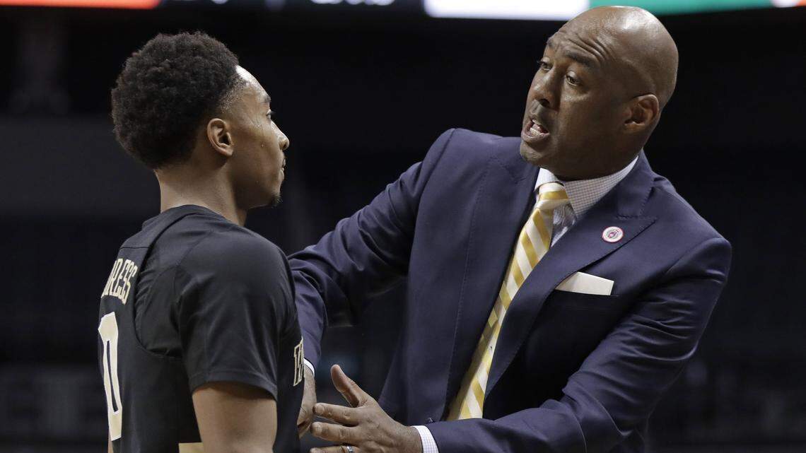Wake Forest head coach Danny Manning, right, talks with Brandon Childress, left, during the first half of an NCAA college basketball game against Miami in the Atlantic Coast Conference tournament in Charlotte, N.C., Tuesday, March 12, 2019.