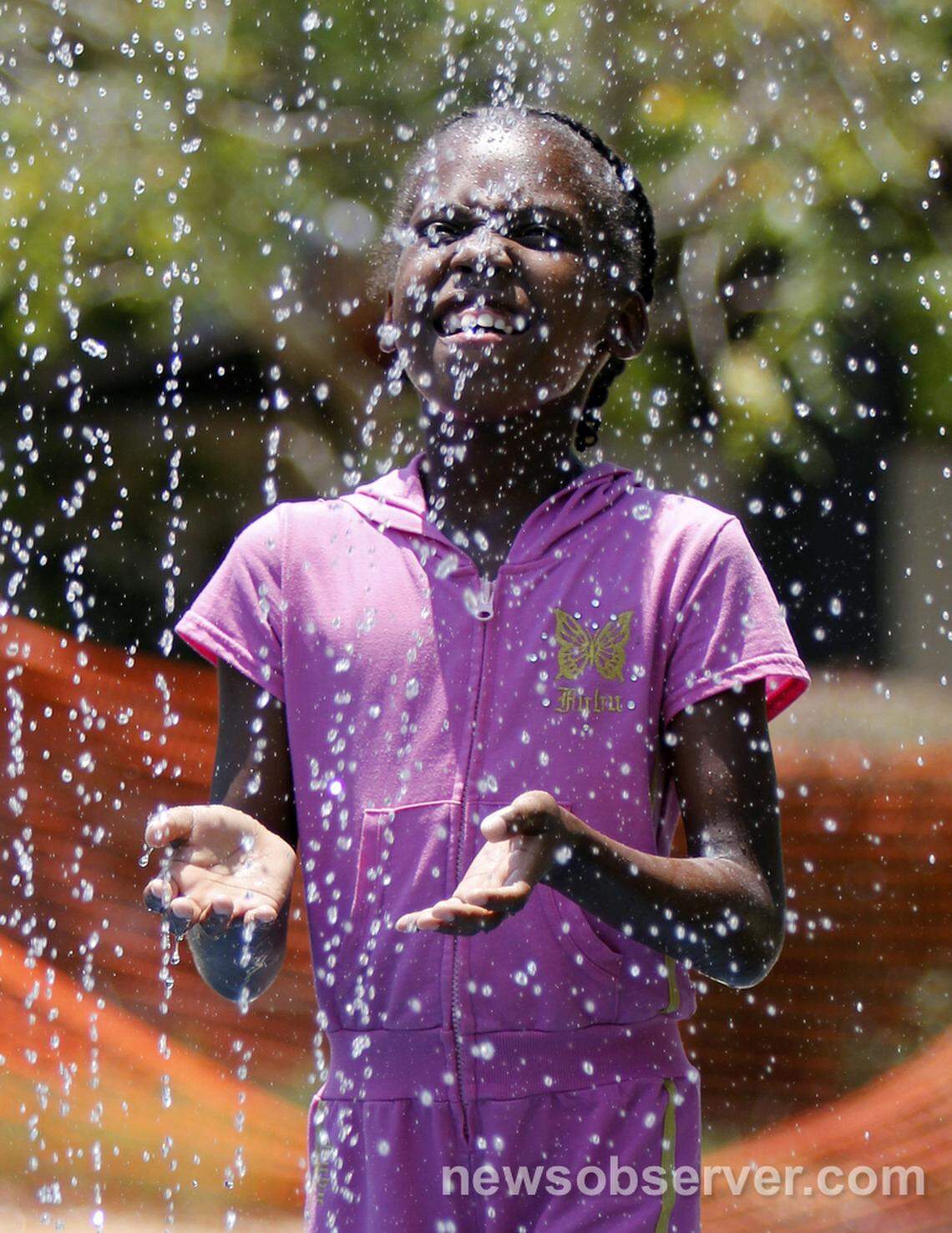 Janiya Bobbitt, 7, feels the cooling water of a vertical sprayer Friday afternoon, July 1, 2011 at the Forest Hills Park spray grounds in Durham, N.C. The city hopes to build new aquatic parks with bond money they’ll ask voters to approve in November 2024.
