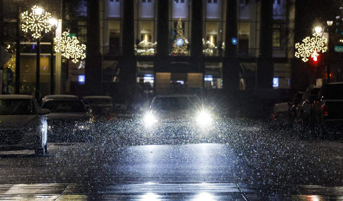 As snow falls a car drives up Fayetteville St. in downtown Raleigh, N.C., Monday evening, Dec. 8. 2025.