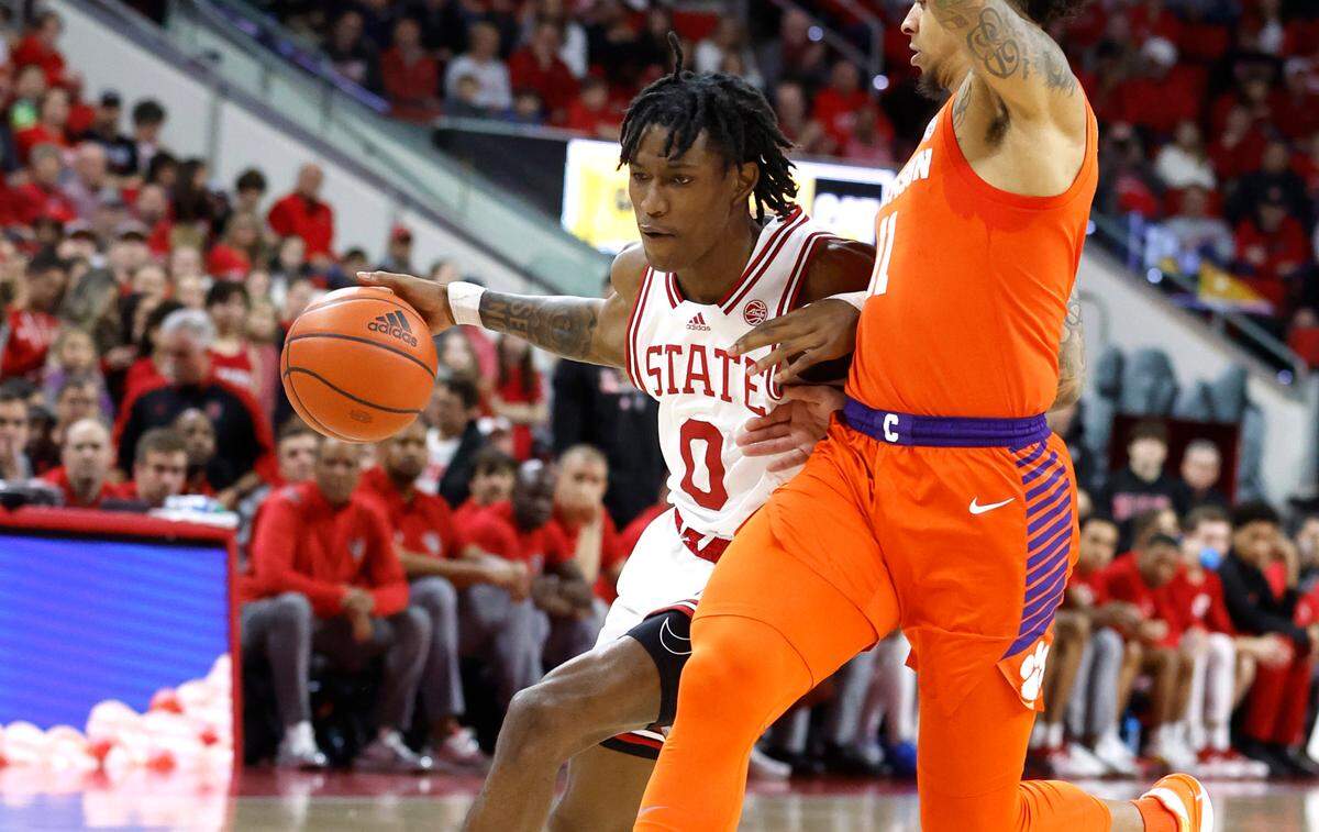 N.C. State’s Terquavion Smith (0) drives by Clemson’s Brevin Galloway (11) during the first half of N.C. State’s game against Clemson at PNC Arena in Raleigh, N.C., Saturday, Feb. 25, 2023.