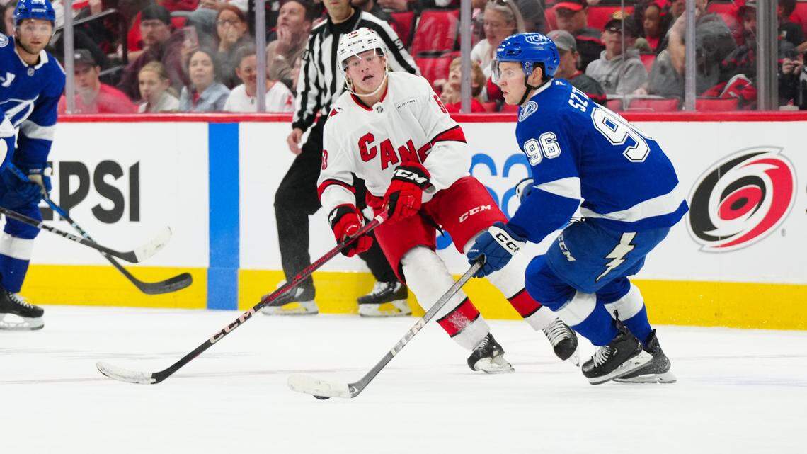 Oct 4, 2024; Raleigh, North Carolina, USA; Tampa Bay Lightning forward Gabrial Saturn (96) skates with the puck past Carolina Hurricanes right wing Jackson Blake (53) during the third period at PNC Arena. Mandatory Credit: James Guillory-Imagn Images