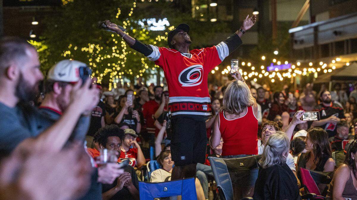 Carolina Hurricanes fans celebrate after a 6-1 victory over the Montreal Canadiens at the conclusion of an NHL Eastern Conference Final watch party in Raleigh's Smoky Hollow district on Friday, May 29, 2026. The victory advanced the Hurricanes to the Stanley Cup Final, marking the franchise's first appearance in the NHL championship series in 20 years.
