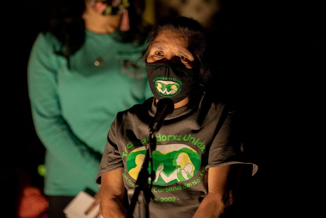 A poultry processing plant worker known by her first name as Evelin speaks about her experiencing contracting COVID-19 in front of an altar assembled to honor the lives of fellow farmworkers and poultry processing workers who have died from COVID-19, during a protest to call on the NC Department of Labor to enforce safety standards and protect workers, on Thursday, Nov. 5, 2020, in Raleigh, N.C.