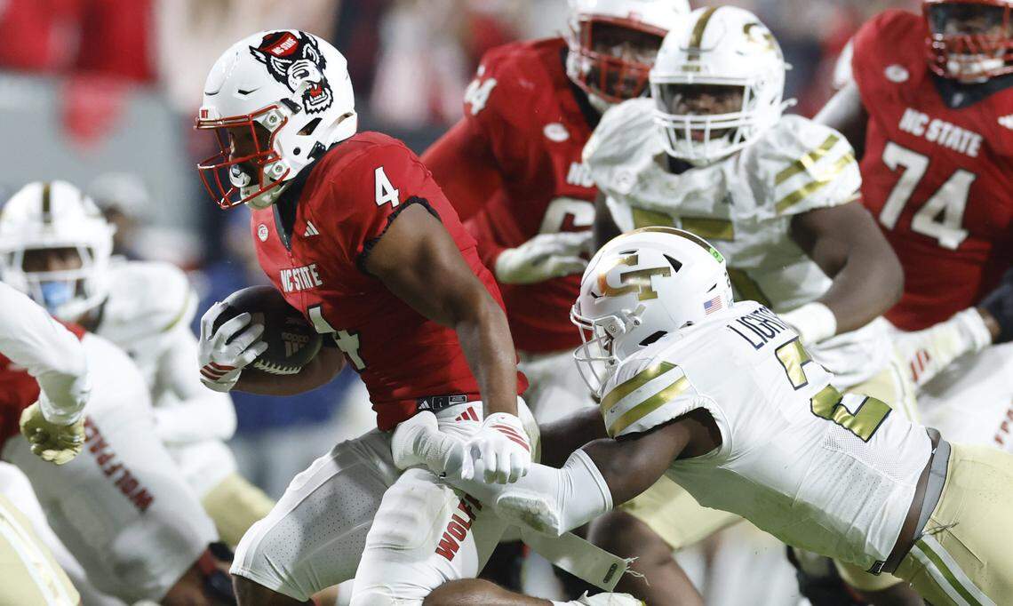 N.C. State running back Duke Scott (4) escapes Georgia Tech linebacker E.J. Lightsey (2) as he gains yards during the first half of N.C. State’s game against Georgia Tech at Carter-Finley Stadium in Raleigh, N.C., Saturday, Nov. 1, 2025.