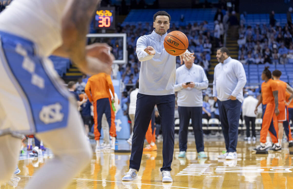 North Carolina assistant coach Marcus Paige works with players during pre-game warm ups, sporting a pair of custom painted shoes on Monday, Feb. 2, 2026 at the Smith Center in Chapel Hill, N.C. The shoes were painted by patients from UNC Children’s Hospital as part of a fundraiser for the fight against pediatric cancer. 