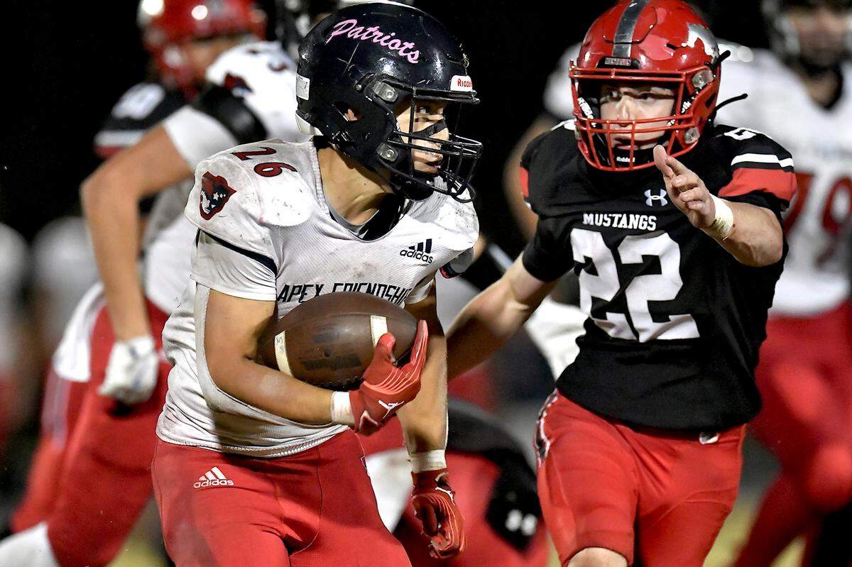 Apex Friendship running back Jaden Avery (26) runs for yardage against Middle Creek’s Evret Farwell (22) during the second half. The Middle Creek Mustangs and the Apex Friendship Patriots met in a football game in Cary, N.C. on October 25, 2024.