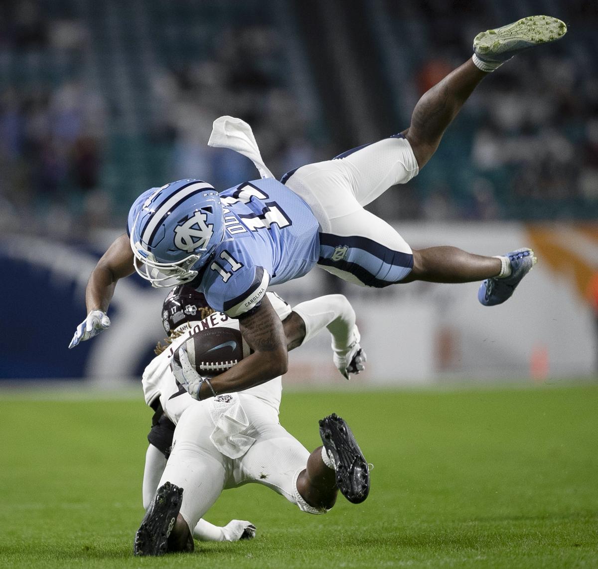 North Carolina’s Josh Down (11) is stopped by Texas A&M’s Jaylon Jones (17) on third down setting up the Tar Heels’ first field goal in the first quarter in the Capital One Orange Bowl on Saturday, January 2, 2021in Miami Gardens, Florida.